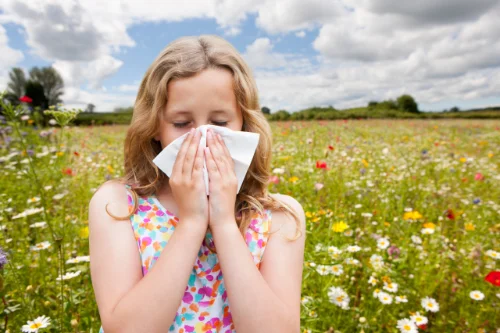 Mädchen mit Allergie auf Blumenwiese